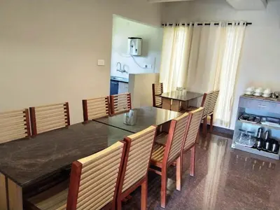 a dining room with a large table and chairs at DEW DROP INN in Ooty