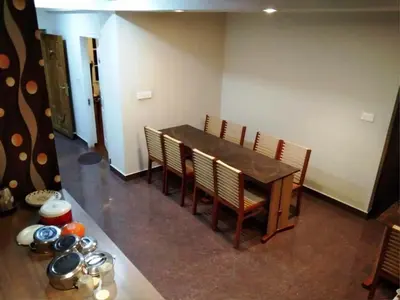 a dining room with a table and chairs and a table and a table at DEW DROP INN in Ooty