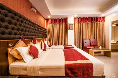 a hotel room with a large bed with red curtains at Aishwarya Residency in Mysore