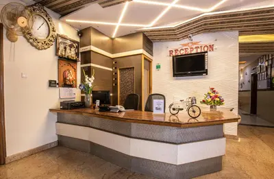 a reception desk in a restaurant with a clock on the wall at Aishwarya Residency in Mysore