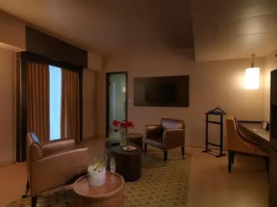 a living room with a couch and chairs and a piano at The Quorum in Mysore
