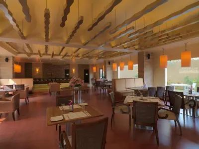a dining room with tables and chairs and lights at The Quorum in Mysore