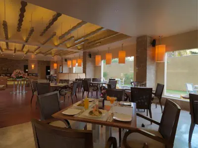 a dining room with tables and chairs in a restaurant at The Quorum in Mysore