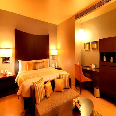 a hotel room with a bed and a desk at The Quorum in Mysore