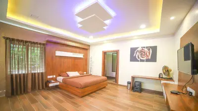 a bedroom with a bed and a flat screen tv at Aira Residency Kothagiri by Lexstays in Kotagiri