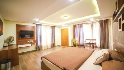 a hotel room with a bed and a television at Aira Residency Kothagiri by Lexstays in Kotagiri