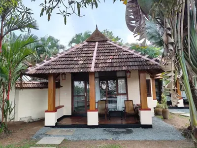 a small house with a thatched roof at Les 3 Elephants in Cherai Beach