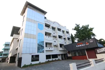 a white building with a sign in front of it at Hotel Kairali in Palakkad
