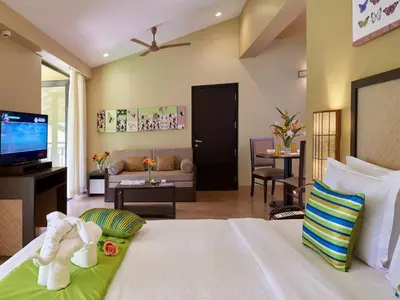 a bedroom with a bed and a living room at Club Mahindra Virajpet, Coorg in Virajpet