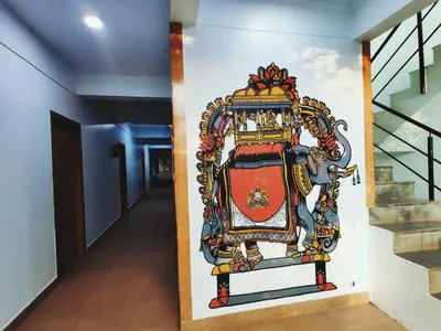 a mural on a wall in a hallway at Raccoon Rooms in Mysore