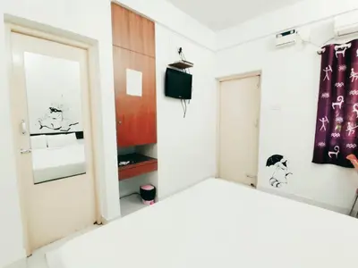 a room with a mirror and a door at Raccoon Rooms in Mysore