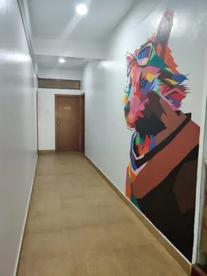 a painting of a cat on the wall in a hallway at Raccoon Rooms in Mysore