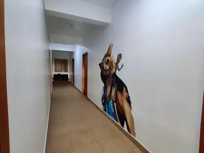 a painting of a rabbit on a wall in a hallway at Raccoon Rooms in Mysore