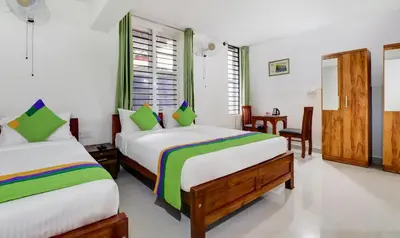 a bedroom with two beds in a room at Treebo New Redfern, Madikeri in Madikeri