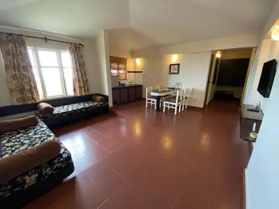 a living room with a couch and a dining room at Mountain Retreat - A Hill Country Resort in Ooty