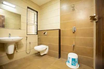 a bathroom with a toilet and a sink at Ponnis Hotel in Palani
