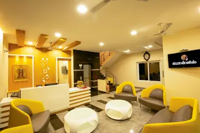 a waiting room with couches and chairs and a sign at Ponnis Hotel in Palani