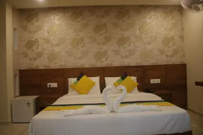 two swans made out of towels sitting on a bed at Hotel Fathima Palace in Kottakkal