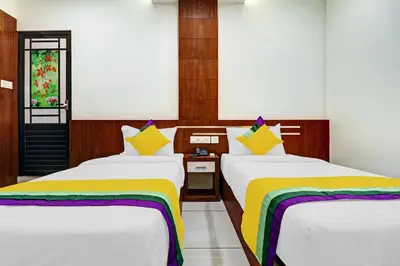 a hotel room with two beds with colorful blankets at Hotel Fathima Palace in Kottakkal