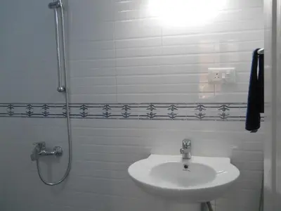 a white bathroom with a sink and a shower at CoconutCrazy! Homestay in Ottappālam