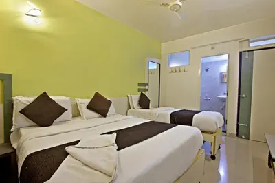 two beds in a room with yellow walls at Mannars Residency in Mysore