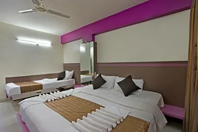 a bedroom with two beds and a large window at Mannars Residency in Mysore