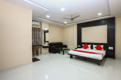 a bedroom with a bed and a living room at Suvarna Suits in Mysore
