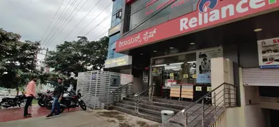 a store on the side of a street with people walking outside at Suvarna Suits in Mysore