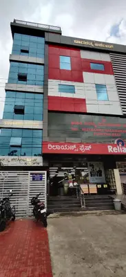 a building with a motorcycle parked in front of it at Suvarna Suits in Mysore