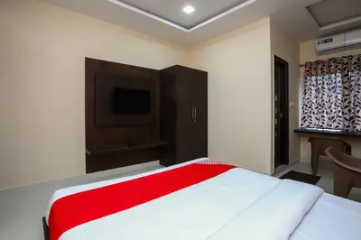 a bedroom with a large bed with a red blanket at Suvarna Suits in Mysore