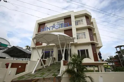 a building with a sign on the front of it at Mintotel Wayanad in Sultan Bathery