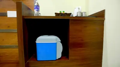 a blue and white trash can in a cabinet at Base9 Cochin Airport Hotel in Nedumbassery