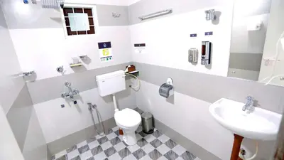a bathroom with a toilet and a sink at Base9 Cochin Airport Hotel in Nedumbassery