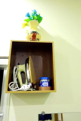 a wooden shelf with a vase on top of it at Base9 Cochin Airport Hotel in Nedumbassery