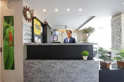 a woman standing behind a counter in a store at FabHotel Prime Suloka Towers - 500m from View point, Kaveri River in Kushālnagar