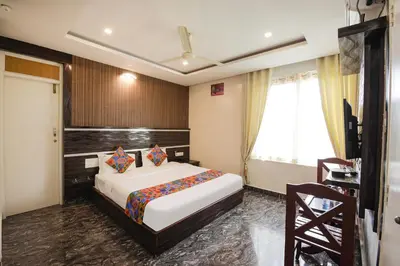 a hotel room with a bed and a window at FabHotel Prime Suloka Towers - 500m from View point, Kaveri River in Kushālnagar