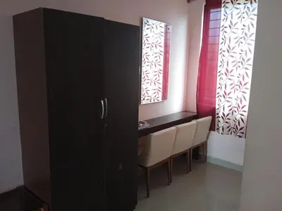 a dining room with a table and two windows at GRAND JP INN Near 2 km from Gundlupet bus stand in Gundlupet