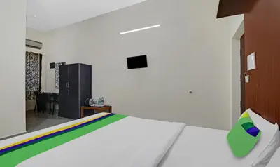 a bedroom with a bed with a tv on the wall at GRAND JP INN Near 2 km from Gundlupet bus stand in Gundlupet