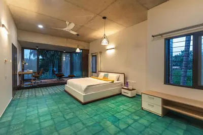a bedroom with a bed and a green floor at SaffronStays Riverstone 3-BR Riverside Villa with Farm Views in Seringapatam