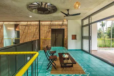 an indoor pool with a table and chairs on a balcony at SaffronStays Riverstone 3-BR Riverside Villa with Farm Views in Seringapatam