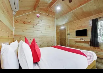 a bedroom with a large white bed with red pillows at Coorg amodhini in Madikeri