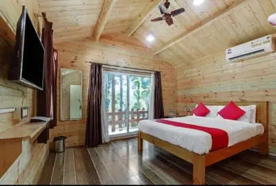a bedroom with a bed in a log cabin at Coorg amodhini in Madikeri