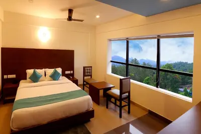 a bedroom with a bed and a large window at Hotel Wilton in Sultan Bathery