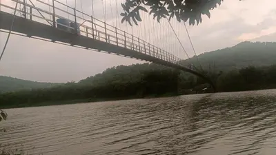 a suspension bridge over a body of water at Jewel Homes Thattekad - ISO 9001 certified Birding & Family Nature Stay in Thattakād