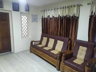 a living room with a couch and two chairs at Heritage Holiday Home in Ooty