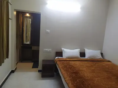 a hotel room with two beds and a mirror at Heritage Holiday Home in Ooty