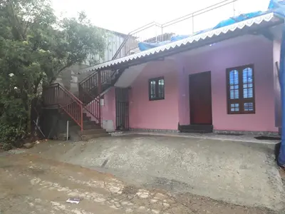 a pink house with a staircase in front of it at Munnar Brindavan Cottage in Munnar