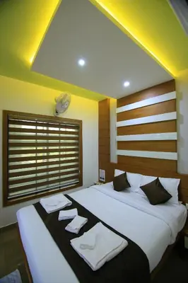 a bedroom with two beds with towels on them at Royal Plaza Wayanad in Vythiri