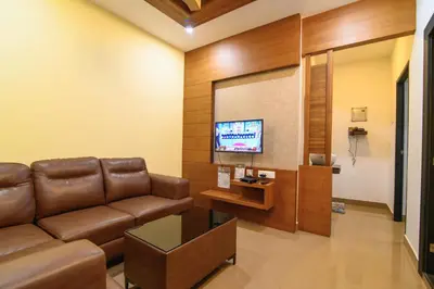 a living room with a couch and a flat screen tv at Royal Plaza Wayanad in Vythiri