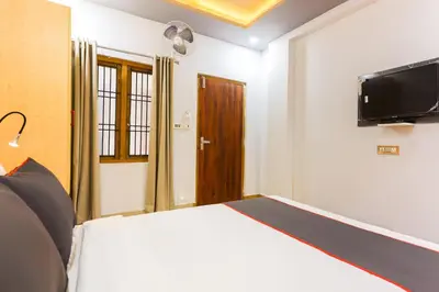 a bedroom with a bed and a flat screen tv at Collection O Marhaba Govindapuram in Calicut